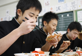 上手に香箱ガニを食べる輪島の学生